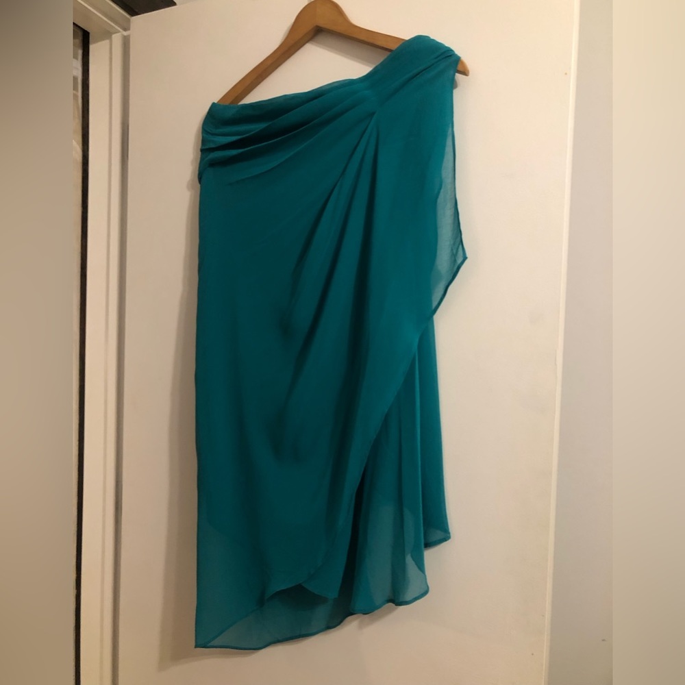 Green holiday party dress with dramatic flowing sleeve